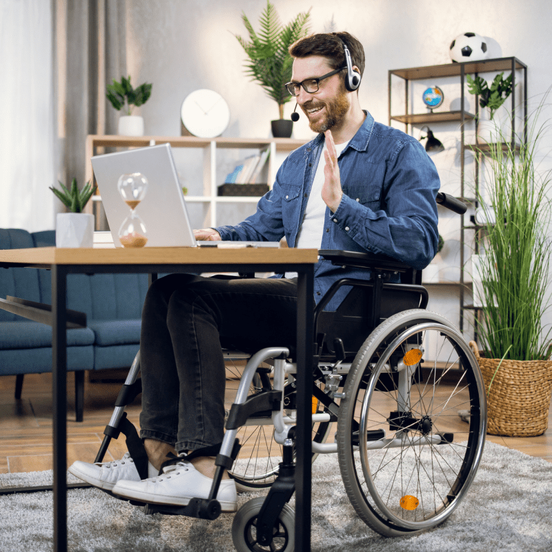 Man in wheelchair with laptop and headset