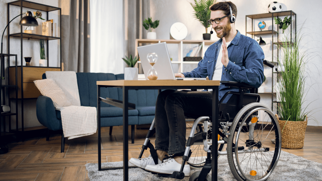 Man in wheelchair with laptop and headset