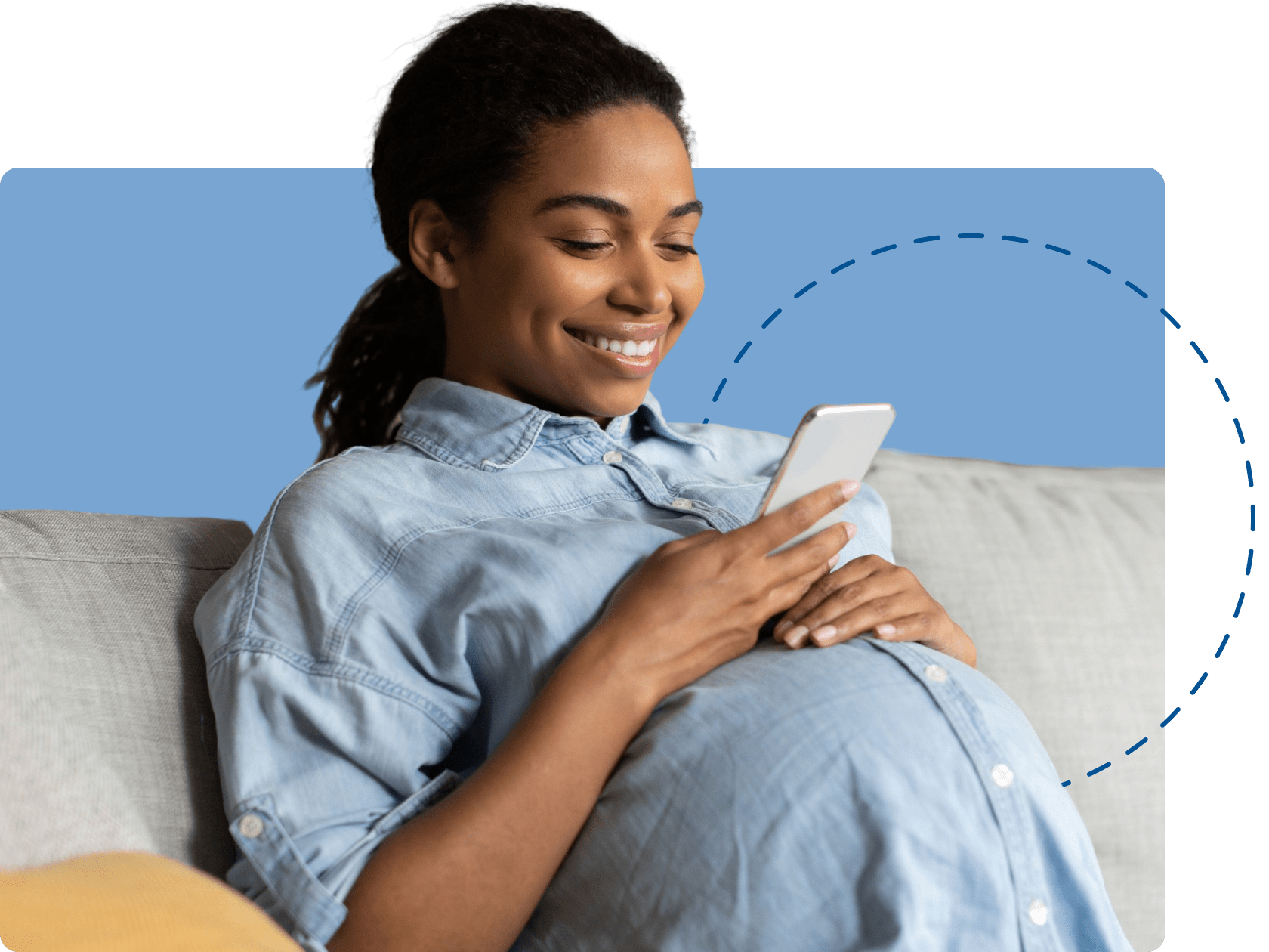 pregnant woman on couch smiling looking at phone